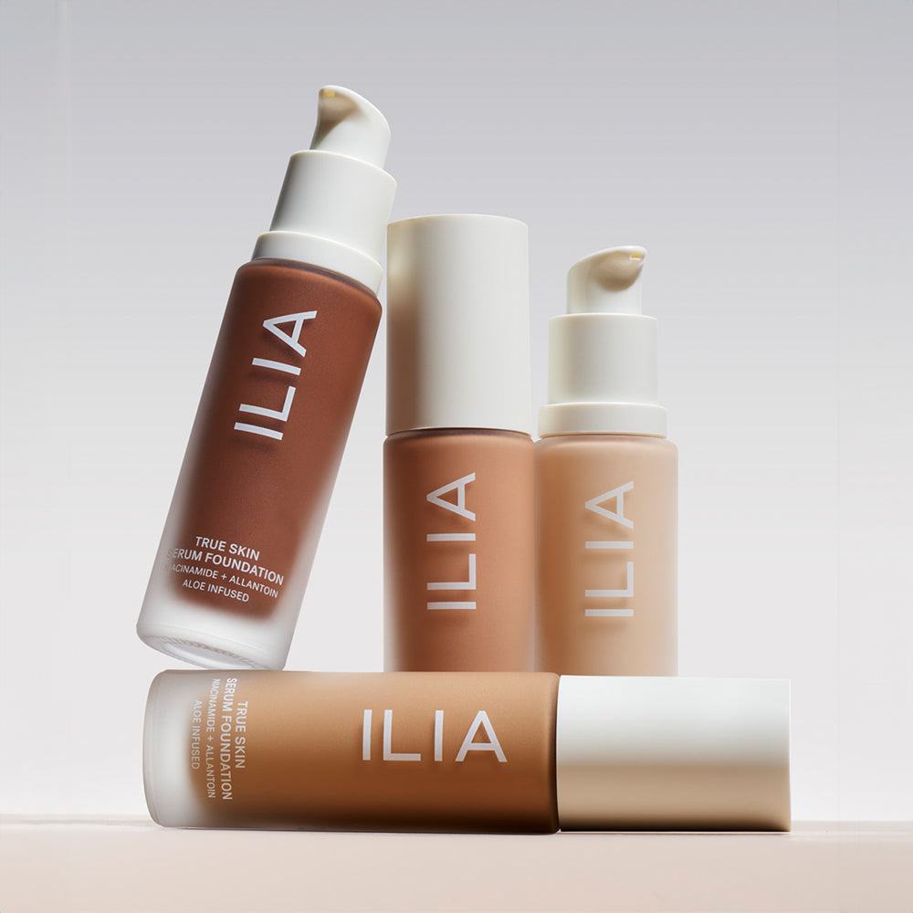 Four shades of True Skin Serum Foundation positioned on a shelf with a tan background.