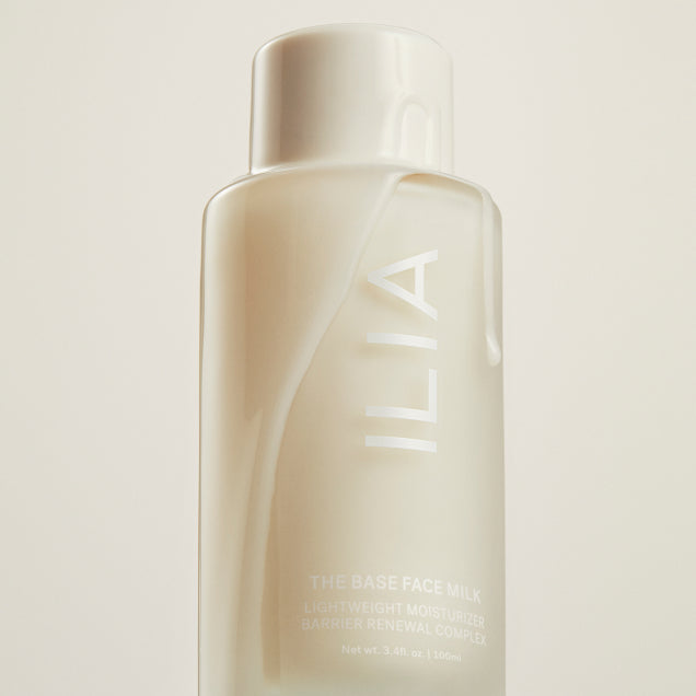 A product image of Face Milk dripping with product against a light background.