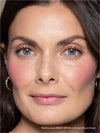 Close-up of a woman's face with makeup, wearing gold earrings.